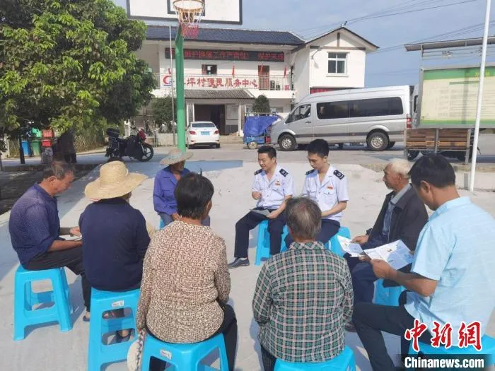 重庆市綦江区税务局“助农小分队”走进草坪村便民服务中心，为该村花生种植大户宣传税惠政策。　徐维达 摄