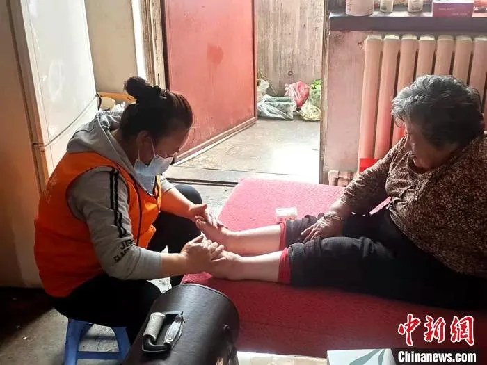 图为志愿者上门服务。　李隽 摄