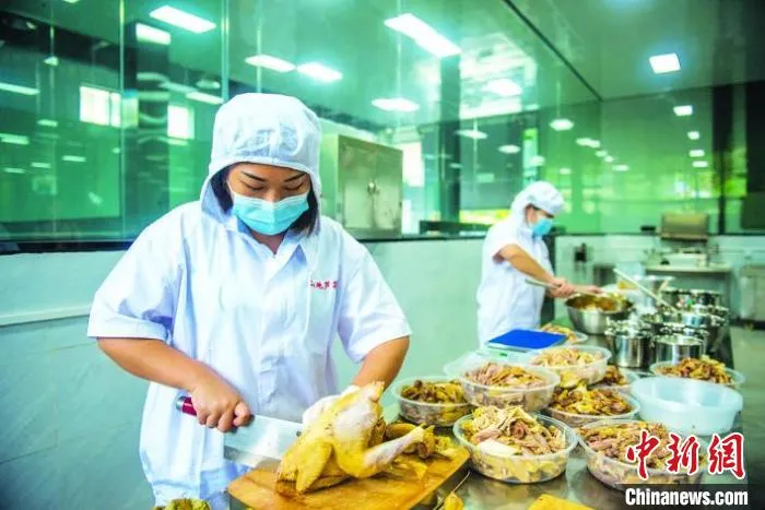 图为芦花鸡研发加工中心，工人分切、制作芦花椒椒鸡。　侯本艳 摄