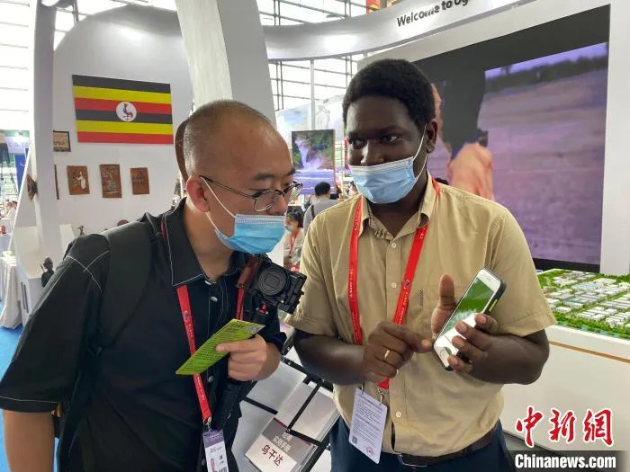 乌干达小伙Ssonko Wilson向参观者介绍相关产品。　王昊昊 摄