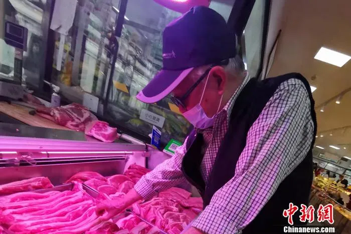 在北京市西城区一家菜市场,一位大爷正在挑肉。 中新网记者 谢艺观 摄 在北京市西城区一家菜市场,一位大爷正在挑肉。 中新网记者 谢艺观 摄