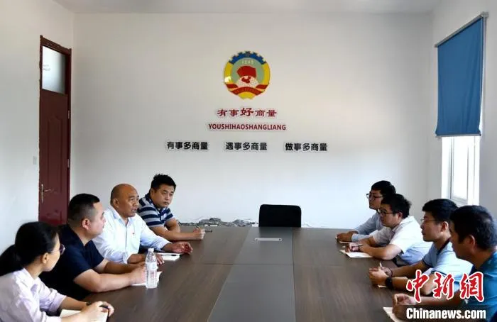 二坝村支部以及村委的几位干部一起讨论二坝村未来发展规划。　朱志庚 摄