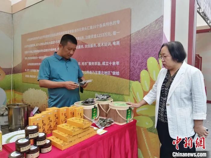 山阴县惠牧源农牧专业合作社联合社理事长陈志龙推介富硒小米。　高雨晴 摄