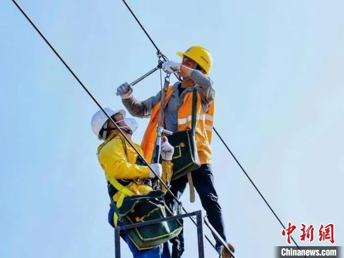 图为铁路工人对中老铁路玉溪至磨憨段接触网平推进行验收作业。　樊儒 摄