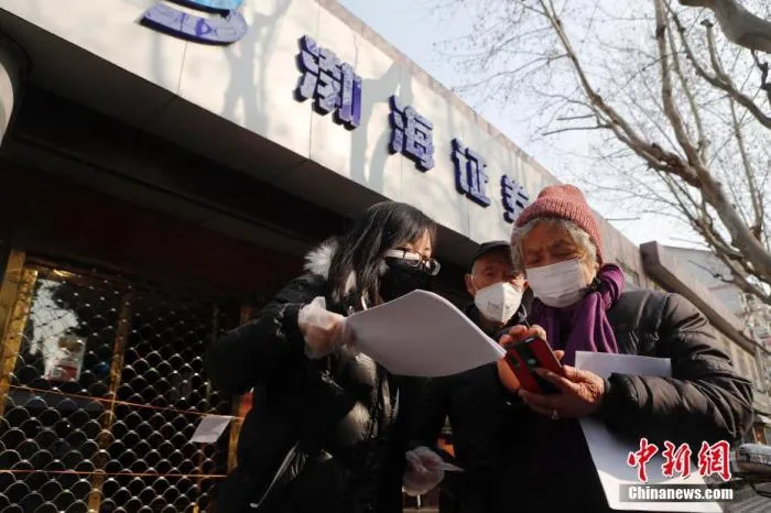 在渤海证券上海彰武路营业部门前，工作人员指导股民网上交易流程。中新社记者 殷立勤 摄