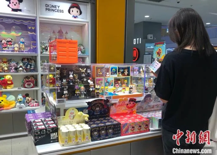 消费者在泡泡玛特门店挑选Molly盲盒。 中新网 左宇坤 摄