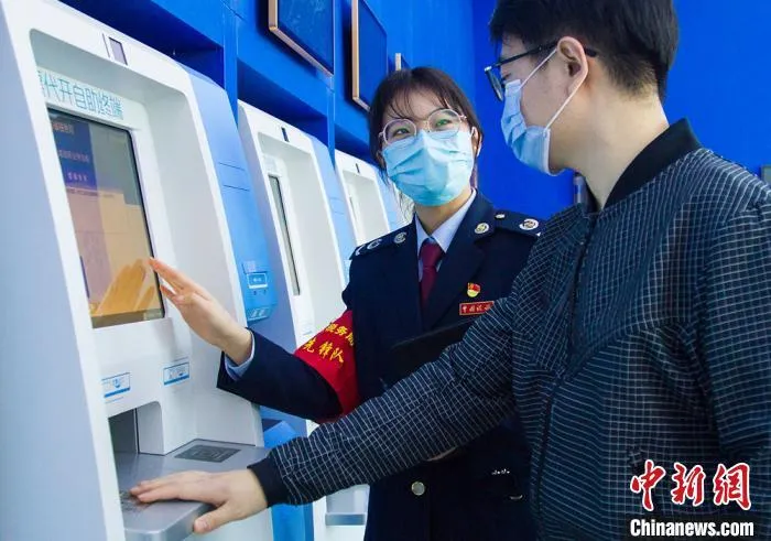 资料图：工作人员指引办税人使用自助设备。　濮志晔 摄
