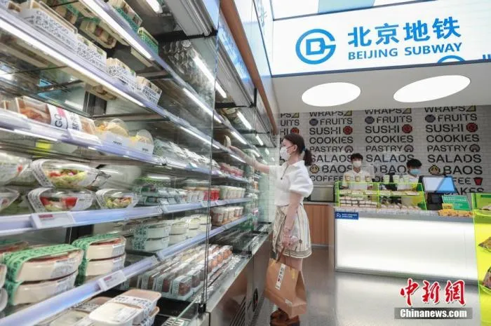 资料图：7月25日，顾客在北京地铁6号线青年路站的便利店内选购商品。当日，北京地铁三处便利店试点开业经营。 中新社记者 贾天勇 摄