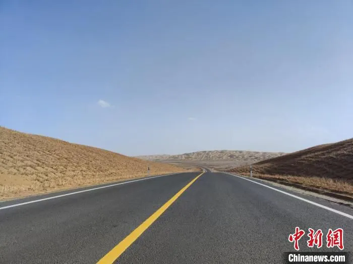在塔克拉玛干沙漠腹地中，一条崭新而平坦的公路延伸向沙漠远方。　喇小飞 摄