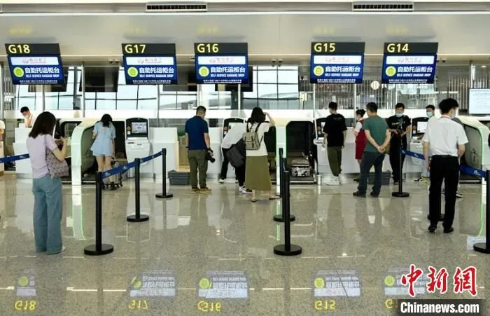 模拟旅客在T1航站楼大厅自助窗口办理行李自助托运。　刘忠俊 摄