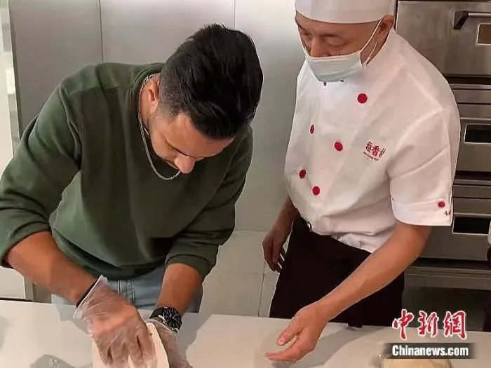 外籍网络名人王慕林在苏州市观前街体验稻香村糕点制作。 宫宏宇 摄