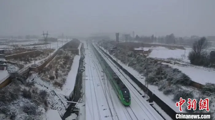图为正在雪天里行驶的动车组列车。　何思远 摄