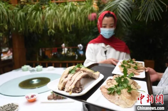 图为服务员端上东乡手抓羊肉。(资料图) 杨艳敏 摄