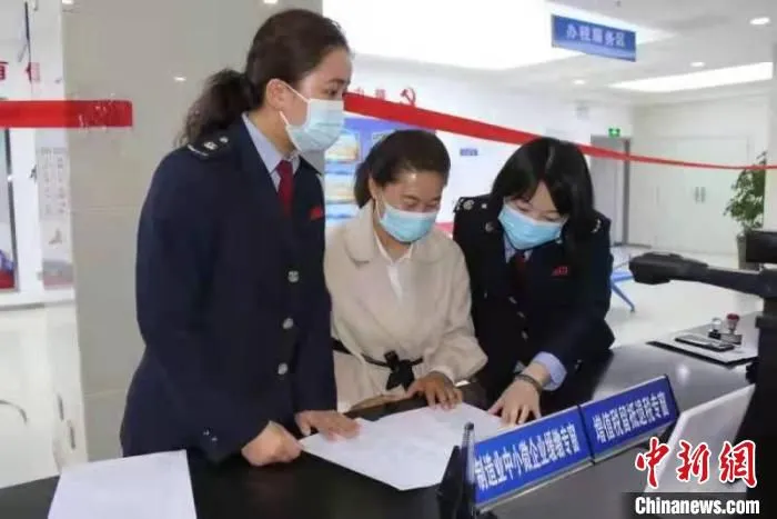 图为武威市凉州区税务干部辅导企业办理留抵退税。　甘肃省税务局供图