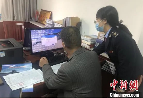 图为税务干部帮助纳税人解决涉税难题。(资料图) 甘肃省税务局供图