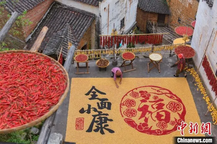 婺源县篁岭村村民用农作物摆起晒秋图，用最淳朴的方式来展现篁岭人在乡村旅游的助力下实现全面小康。　方华彬 摄