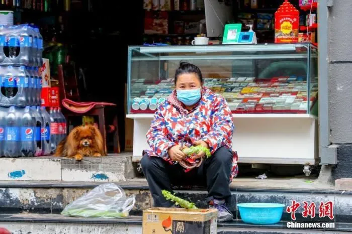 市民在自家小店门外准备晚餐。 中新社记者 张畅 摄