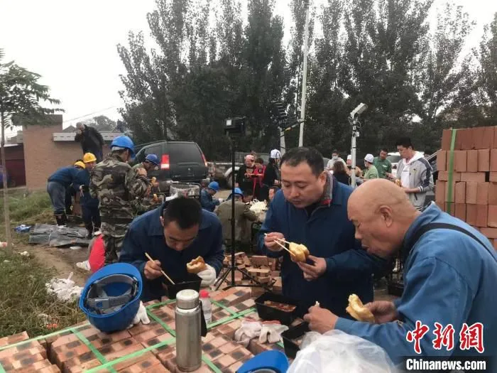 站着吃点饭，吃完继续干。　赵春燕 摄