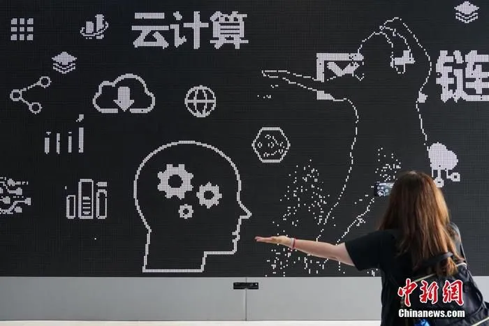 资料图：一名参观者在国家大数据(贵州)综合试验区展示中心互动性磁力翻转屏前进行体验。中新社记者 瞿宏伦 摄