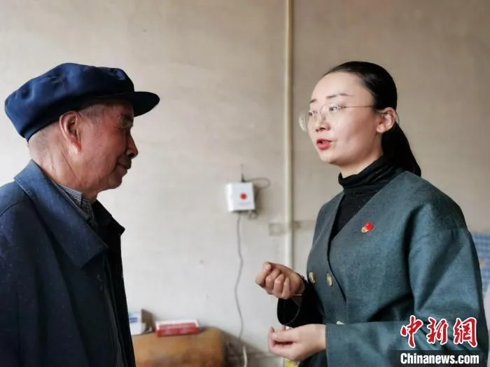 图为乡镇干部向独居老人介绍“马上帮”大数据综合服务平台呼叫器的操作方法。　张添福 摄