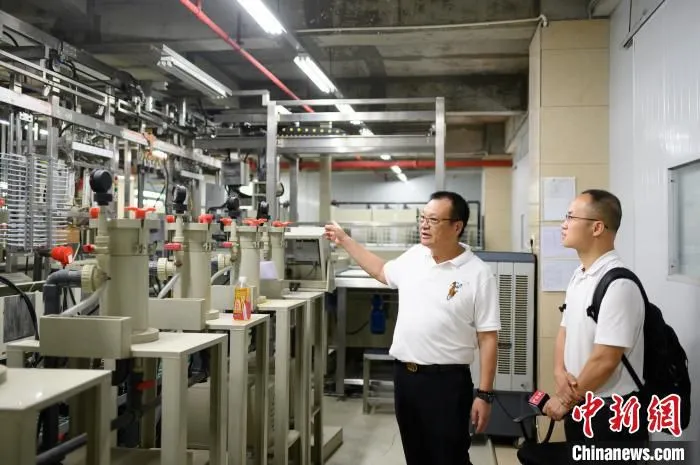 广州明毅电子机械有限公司董事长邓高荣正向记者介绍工厂内的设备功能 陈楚红 摄