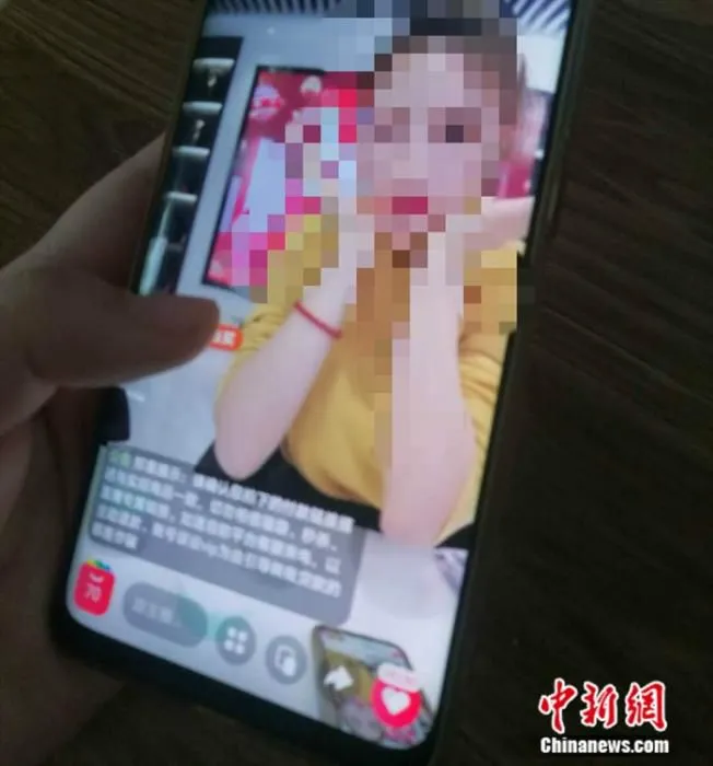 资料图：消费者在观看商品直播。 谢艺观 摄
