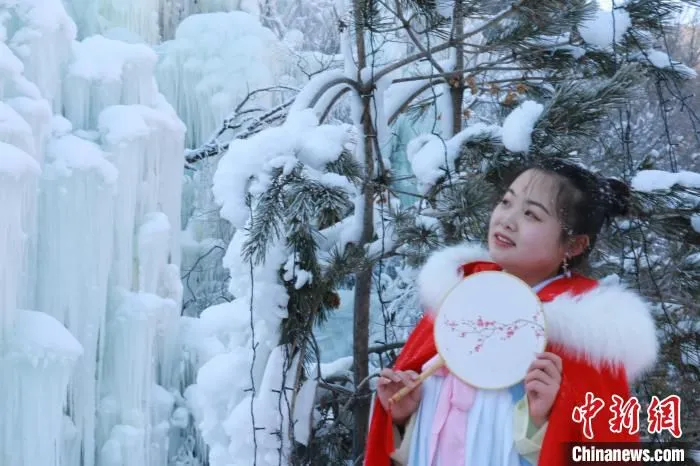 图为身着汉服的游客在冰瀑前拍照留念。　张婧 摄