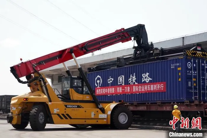 图为装卸人员正在有条不紊地指挥跨境集装箱吊装作业。　谭媛元 　摄