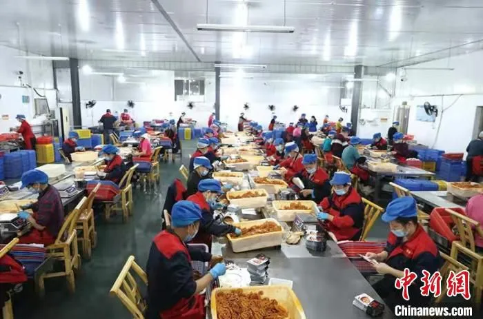 普金公司生产车间内，工人们正在包装卤好的藕片、毛豆等休闲食品。　刘珂 摄