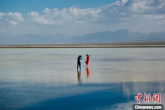 图为游客在天空壹号景区内的盐湖中拍照。　马翔 摄