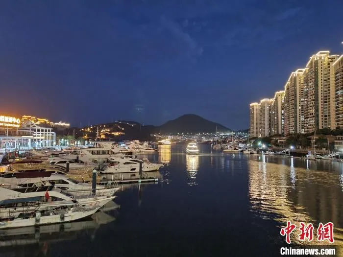 夜幕中，两艘布满彩灯的旅游船驶离码头，载着游客朝海上开去。　记者王晓斌 摄