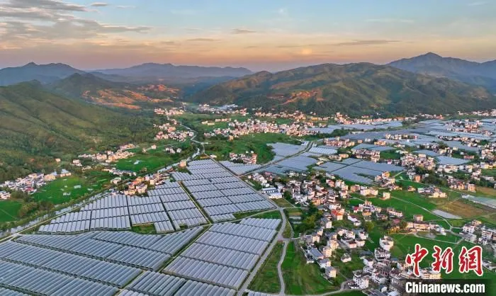 航拍江西省赣州市于都县梓山镇潭头村，夕阳余晖映衬着整齐排列的蔬菜大棚。(资料图) 朱海鹏 摄
