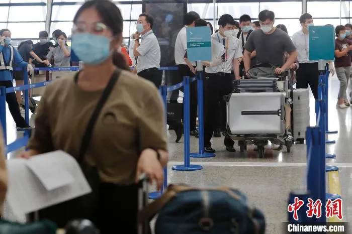 工作人员正在对旅客进行信息核查。　殷立勤 摄