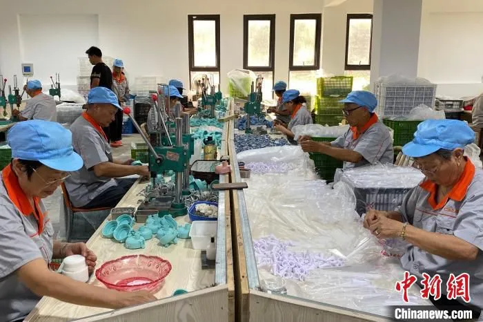 村民组装瓶盖。　钱晨菲 摄