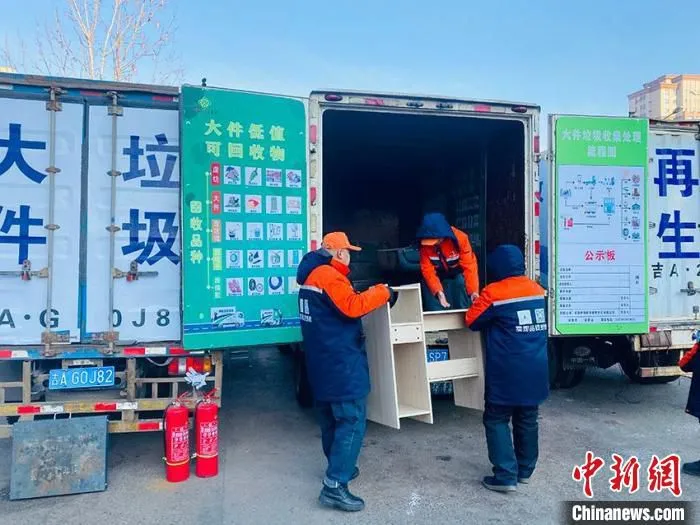 工作人员将大件垃圾搬运到“流动转运车”并送往““可回收物分拣中心” 李丹 摄