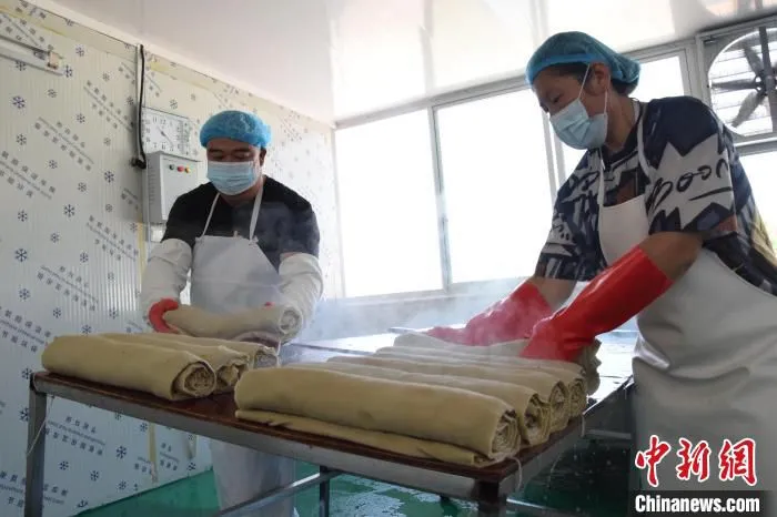 图为三河市征亮食品有限公司生产车间，一卷卷冒着热气的豆片儿新鲜出炉。　高澍 摄