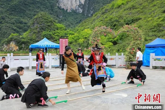 图为游客在壮瑶同胞带领下跳竹竿舞 谢永翠 摄 图为游客在壮瑶同胞带领下跳竹竿舞 谢永翠 摄