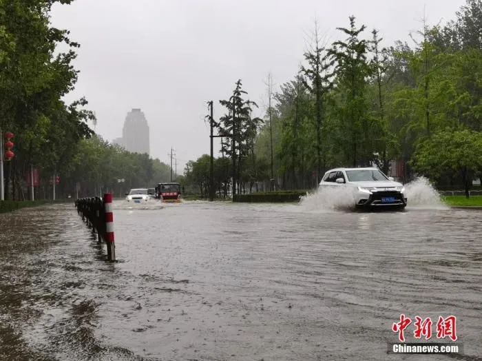7月20日，河南郑州，车辆从积水路段通过。近日，郑州连遭暴雨袭击，持续强降雨导致部分街头积水严重。 中新社记者 李贵刚 摄