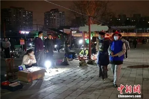 4月2日晚，打扮成侍卫在“鬼市”巡逻的安保人员。中新社易海菲 摄