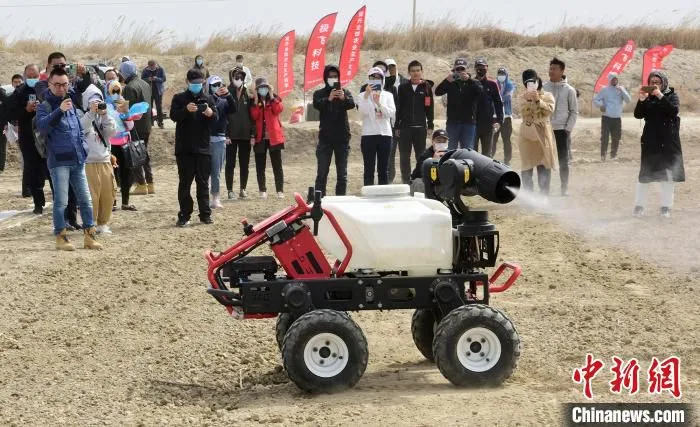 技术人员展示可进行打农药、锄草的多功能农用全自动机器人。　陈剑飞 摄