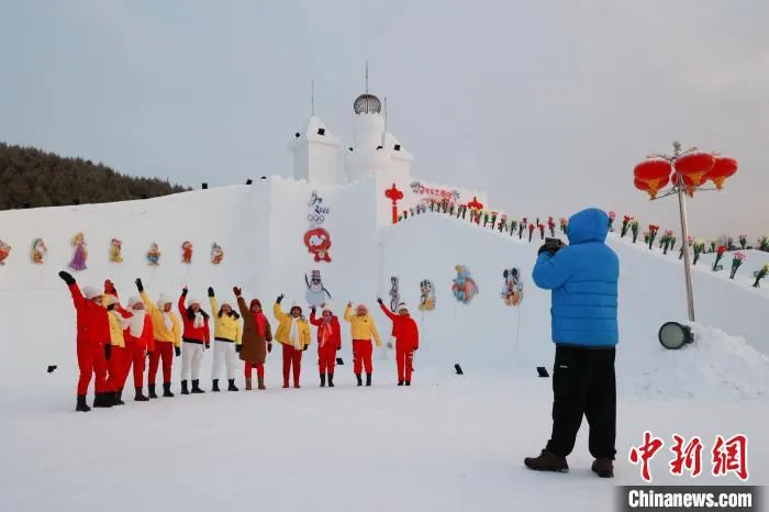 游客在雪堡前合影留念。　吕阳 摄