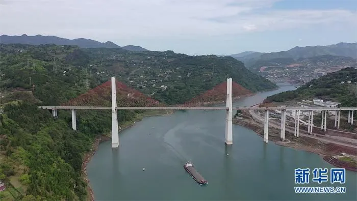 4月8日，G42沪蓉高速上一桥飞架两岸，货轮行驶在江面上。新华网 向进 摄