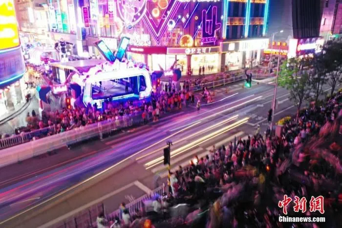 5月2日晚，江西南昌，民众在胜利路步行街休闲购物。为恢复百年老街的往日繁华，当地开展胜利路步行街“胜利归来” 主题活动，打造潮玩、消费于一体的活动街区，“五一”假期吸引民众，形成新的节日经济、夜间经济和文化经济。(无人机照片) 中新社记者 刘占昆 摄