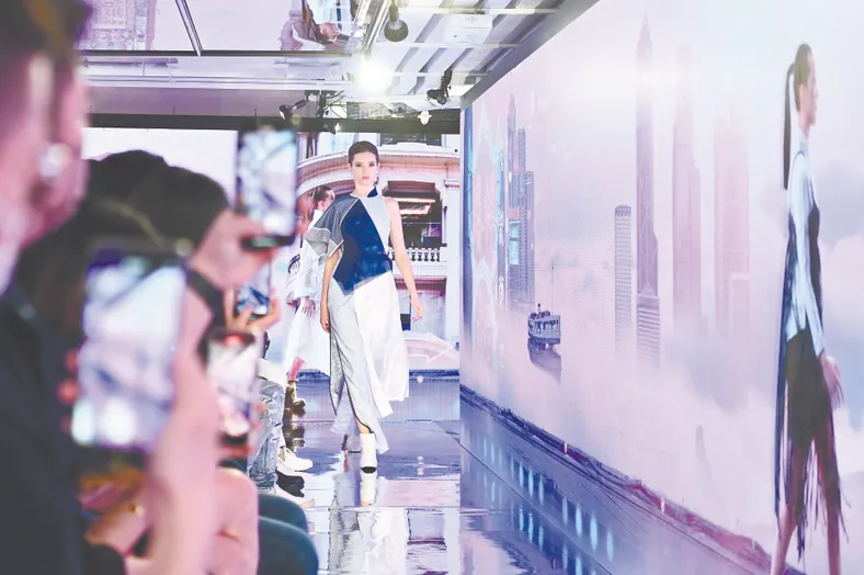 6月9日，在香港举行的时装项目“Juxtaposed 2022 FASHION META”展览，以实体及虚拟的时装展现，让入场人士欣赏不同时装风格。图为实体与虚拟结合的时装表演。(中新社记者 李志华 摄)