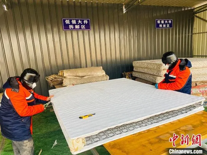 分拣中心拆解工人正在拆解旧床垫 李丹 摄