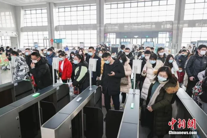 2022年1月3日，旅客在江苏连云港市赣榆火车站进站乘车。当日是元旦假期最后一天，全国铁路迎来返程客流高峰。 中新社发 司伟 摄 图片来源：CNSPHOTO
