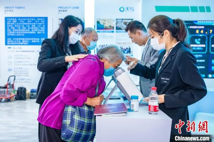 AI眼底筛查设备吸引了不少老年人的关注。　徐珊珊 摄