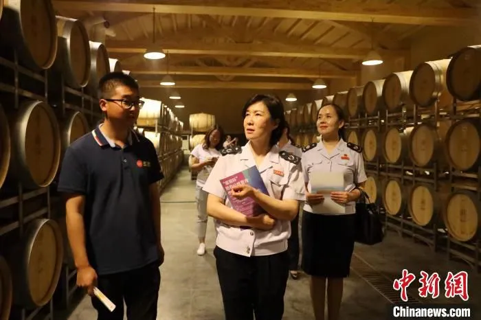 国家税务总局鄯善县税务局工作人员向企业进行政策宣传并解答疑问。　马晓慧 摄