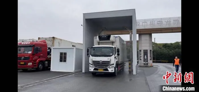 在龙门架对车辆进行消杀后 进入进博会冷链食品总仓。　上海市场监管局 摄