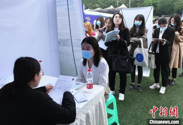 图为求职者排队应聘。　周毅 摄
